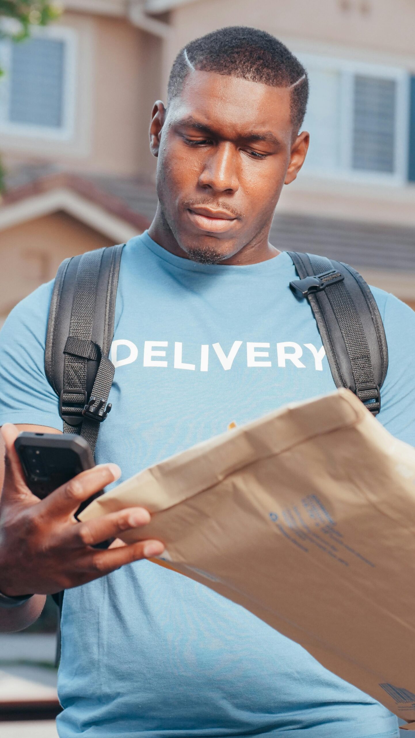 Anyware delivery agent looking at a brown envelope to verify customer verification number